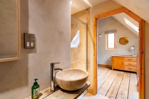 a bathroom with a large stone sink and a shower at ‘The Little House on The Priory’ with Hot Tub in Abergavenny