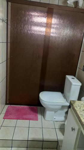 baño con aseo y pared marrón en Apartamento Bem Localizado, en Florianópolis