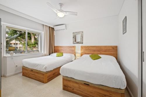 two beds in a room with a window at Piso con 2 habitaciones, 2 terrazas y piscina in Torremolinos