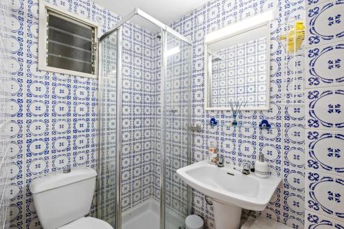 a blue and white bathroom with a toilet and a sink at Piso con 2 habitaciones, 2 terrazas y piscina in Torremolinos