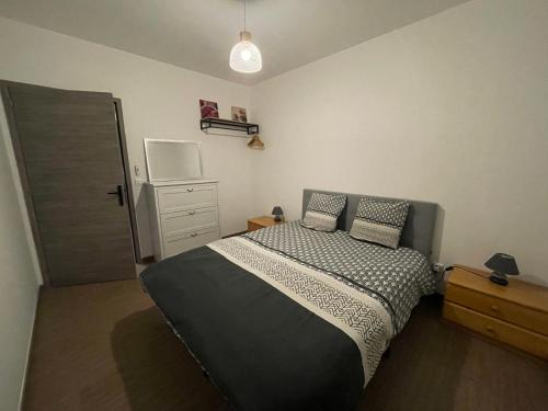 a bedroom with a bed and a dresser and a refrigerator at L'Orée des Champs in Lérouville