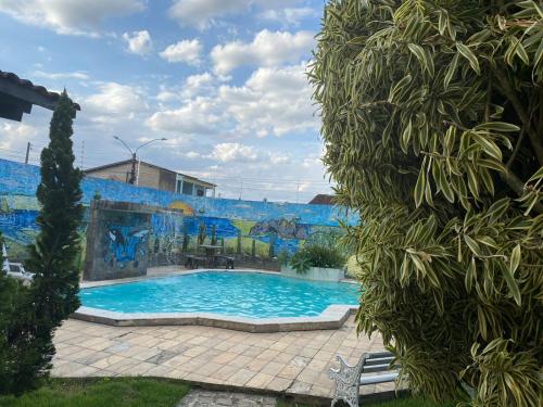 a swimming pool in front of a wall with a mural at CONFORT HOTEL ARAPIRACA in Arapiraca