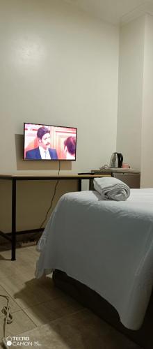a bedroom with a bed and a tv on a table at Puma Aparthotel - Nyarutarama in Kigali