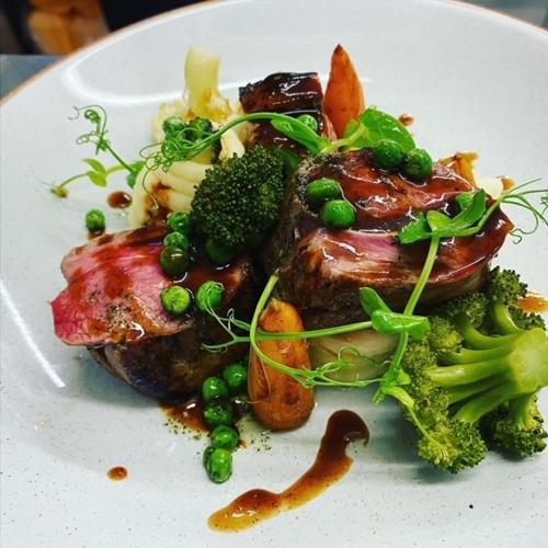 a white plate of food with broccoli and meat at The Granby Inn in Longframlington