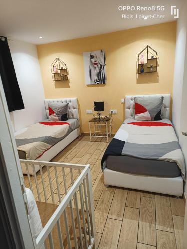 a bedroom with two beds and a stair case at Appartement avec Terrasse in Blois