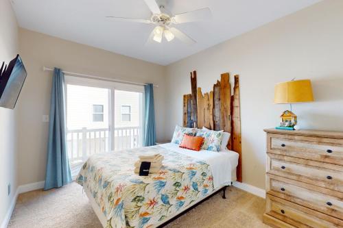 een slaapkamer met een bed, een dressoir en een raam bij Shore Thing in Surf City