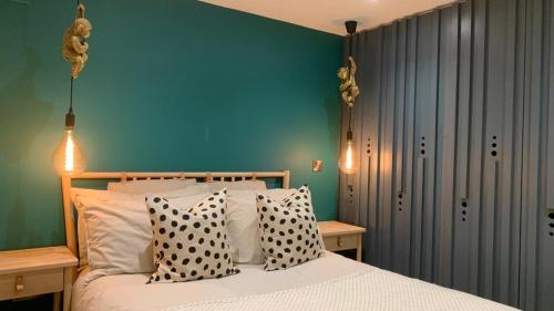 een slaapkamer met een bed met polka dot kussens bij Parkside Lodge - Luxury Coastal Hideaway for Two in Brixham