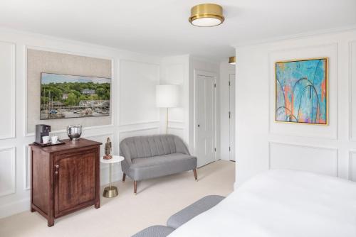 una camera con letto, sedia e tavolo di Relais Chateaux Camden Harbour Inn a Camden