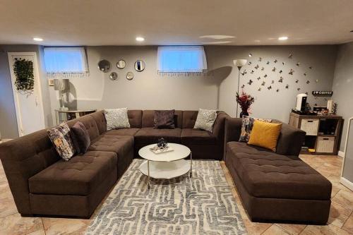 a living room with a brown couch and a table at Beautiful & Cozy one Bedroom Apartment near Boston & Airport in Saugus