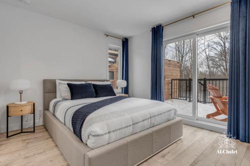 1 dormitorio con cama y ventana grande en Chalet Bellevue Luxe avec Spa et local à velo, en Pont-Rouge