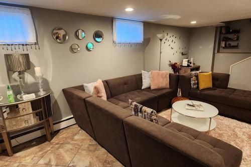 a living room with a brown couch and a table at Beautiful & Cozy one Bedroom Apartment near Boston & Airport in Saugus
