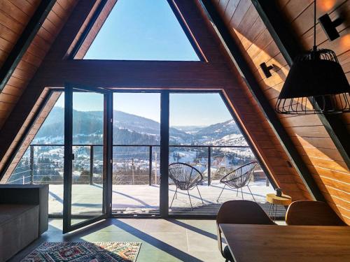 a large window in a room with a table and chairs at Mirador Cottage in Slavske