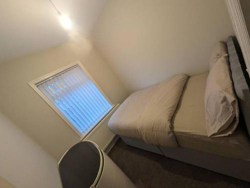 a small bedroom with a bed and a window at 3 bed home, pool-hot tub & ev charger in Darlington
