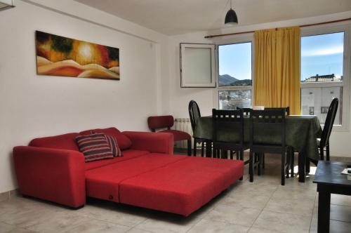 sala de estar con sofá rojo y comedor en Depto con hermosa vista al lago y cerros cerca de todo en San Carlos de Bariloche