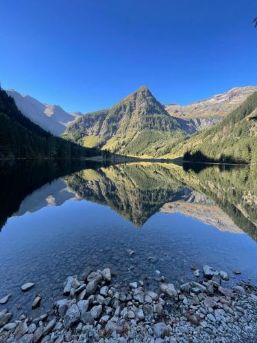 a view of a mountain reflecting in a lake at Burglehnerhof in Ramsau am Dachstein