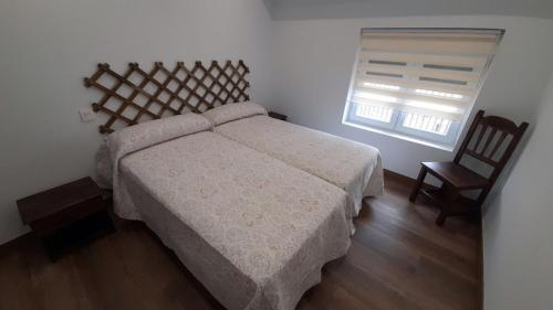 Barruelo de Santullán的住宿－Casa Lorea，一间卧室配有一张大床和两把椅子