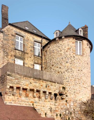 un grand bâtiment en briques avec des fenêtres au-dessus dans l'établissement La maison sur les remparts, à Domfront