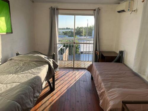 sypialnia z 2 łóżkami i dużym oknem w obiekcie María Chusena alojamiento 2 w mieście Fray Bentos