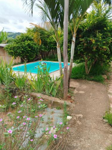 einen Pool in einem Garten mit Bäumen und Blumen in der Unterkunft BiaMar in Luminárias