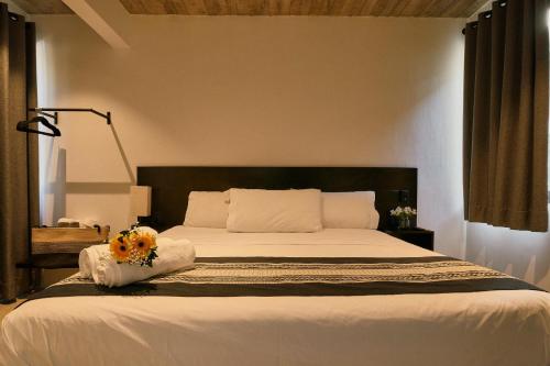 een slaapkamer met een bed met een bloem erop bij Aldea Paraíso - Adults only - Boutique hotel in Puerto Escondido