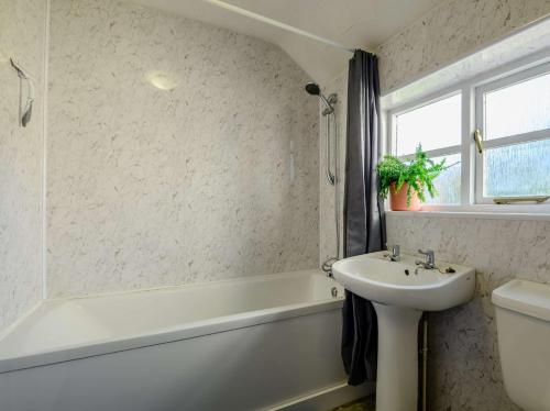 uma casa de banho com um lavatório e uma banheira e um lavatório em 2 Bed in Llangynidr BN052 em Llangynidr