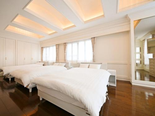 um quarto com 3 camas e uma grande janela em Pleasure Maruyama - Vacation STAY 52729v em Sapporo