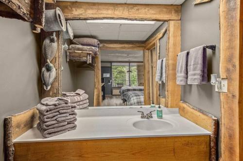 a bathroom with a sink and a mirror at Stonegate Lodge Saltwater Pool 2 Queen Beds Firepit Fast WiFi Room #307 in Eureka Springs
