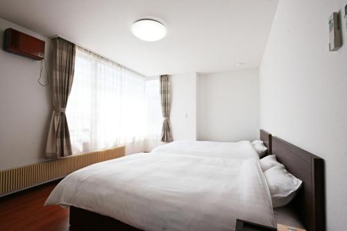 Un dormitorio con una gran cama blanca y una ventana en Pleasure Maruyama - Vacation STAY 52780v, en Sapporo
