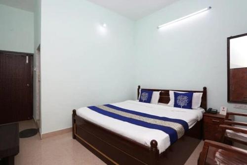 a bedroom with a bed with blue pillows and a mirror at Hotel Riverside Retreat ! Puri - ViDi Group in Puri