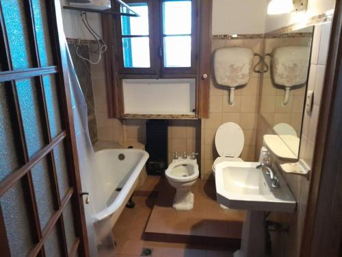 a bathroom with a toilet and a tub and a sink at Apartamento de estilo en edificio patrimonial in Montevideo