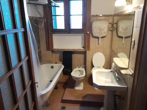 y baño con aseo, bañera y lavamanos. en Apartamento de estilo en edificio patrimonial, en Montevideo