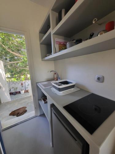 a small kitchen with a counter and a window at Deep Blue Studios in Logaras