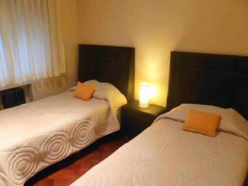 1 dormitorio con 2 camas con almohadas de color naranja en Luminoso 3 ambientes en el centro Cordoba y Maipu en Buenos Aires