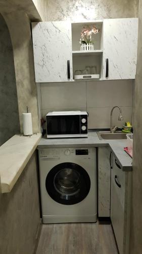 a kitchen with a washing machine and a microwave at Cornelius Studio in Galaţi