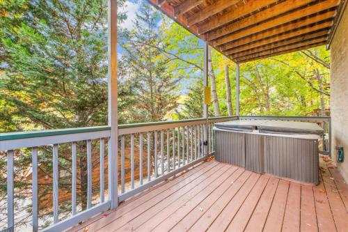 a large porch with a hot tub on a wooden deck at Valley Heights home in Pigeon Forge