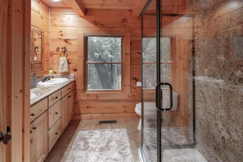 uma casa de banho com um WC e uma cabina de duche em vidro. em Exquisite Log Cabin in the Pines and Very Private em Sonora