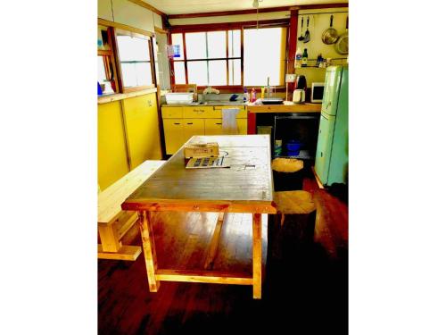 eine Küche mit einem Holztisch in der Mitte in der Unterkunft Obasute Guesthouse Nakaraya - Vacation STAY 31596v in Chikuma