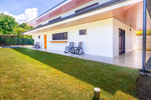 a patio of a house with chairs in a yard at Luxury 2 bedroom, walking distance to beach in Uvita