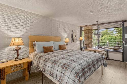 a bedroom with a bed and a desk and a window at Stonegate Lodge King Bed Fast WiFi 40in TV Salt Water Pool Room #309 in Eureka Springs