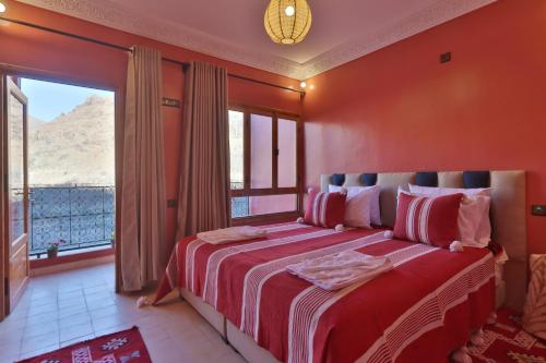 a bedroom with a large bed with a large window at La Perle de Neige in Imlil