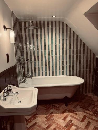 a bathroom with a bath tub and a sink at The Leicester Arms Country Inn in Penshurst