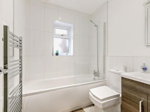 baño blanco con bañera, aseo y lavamanos en 2 Bed in Barnstaple 89950, en High Bickington