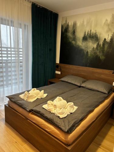 a bed with two white towels on top of it at Apartament Centrum Park 654 in Szklarska Poręba