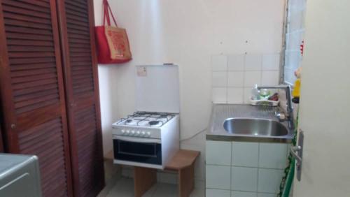 a small kitchen with a stove and a sink at Appartement EMISYD in Libreville