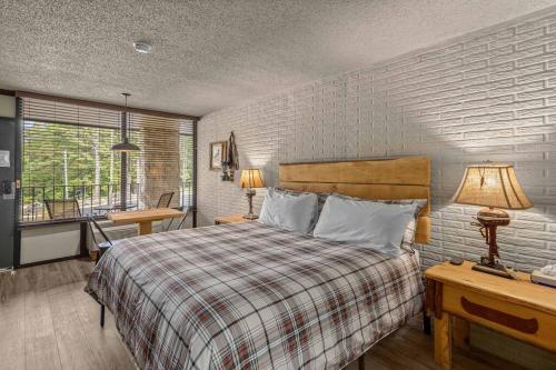 a bedroom with a bed and a desk and a window at Stonegate Lodge King Bed, WiFi, 50in TV, Fire Pit, Salt Water Pool Room # 310 in Eureka Springs