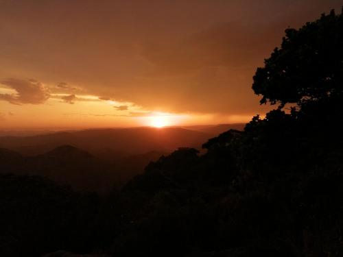 a sunset in the mountains with the sun setting at Louis at Magwa Falls in Lusikisiki