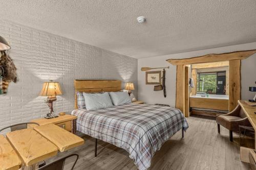 a bedroom with a bed and a table and a window at Stonegate Lodge King Bed, WiFi, 50in TV, Fire Pit, Salt Water Pool Room # 310 in Eureka Springs