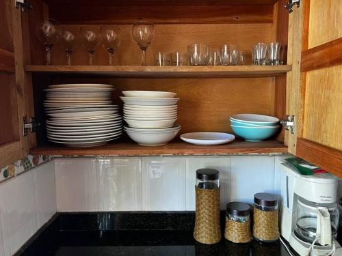 a kitchen cabinet with plates and bowls and glasses at Casa finca Santiago Tolú 