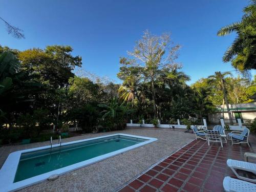 a swimming pool in a yard with chairs and a table at Casa finca Santiago Tolú 