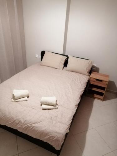 a bedroom with a bed with two towels on it at ANIA'S APARTMENT ( ΣΤΟ ΚΕΝΤΡΟ ΤΗΣ ΚΟΖΑΝΗΣ ) in Kozani